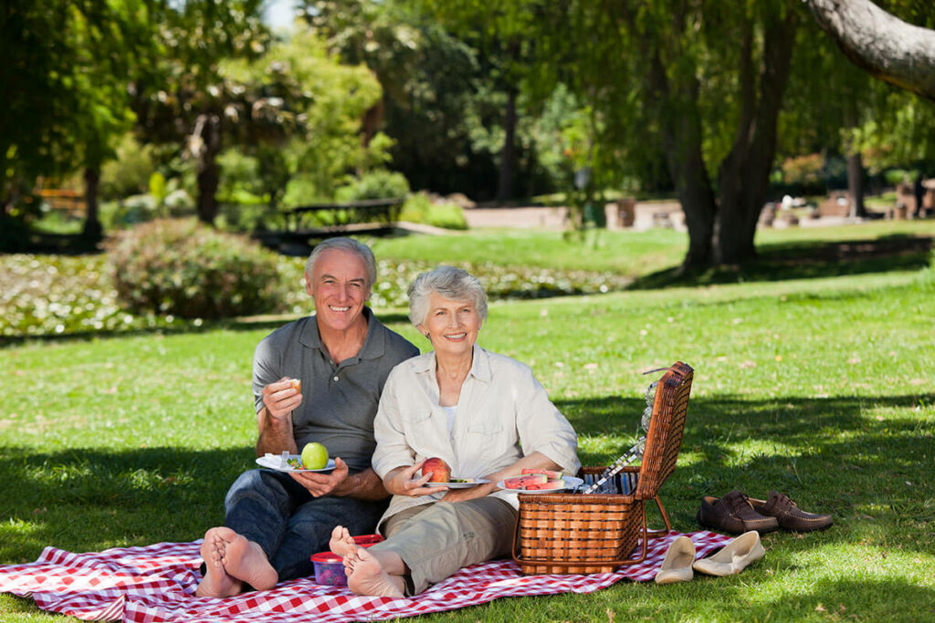 Imagine Senior Living | Senior couple having a picnic under a tree